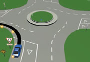 Picture of a car signalling left at a multi-laned roundabout