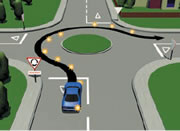 Picture of a car signalling right at a single-laned roundabout